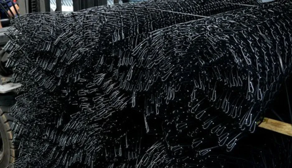 Stacked rolls of black chain wire mesh