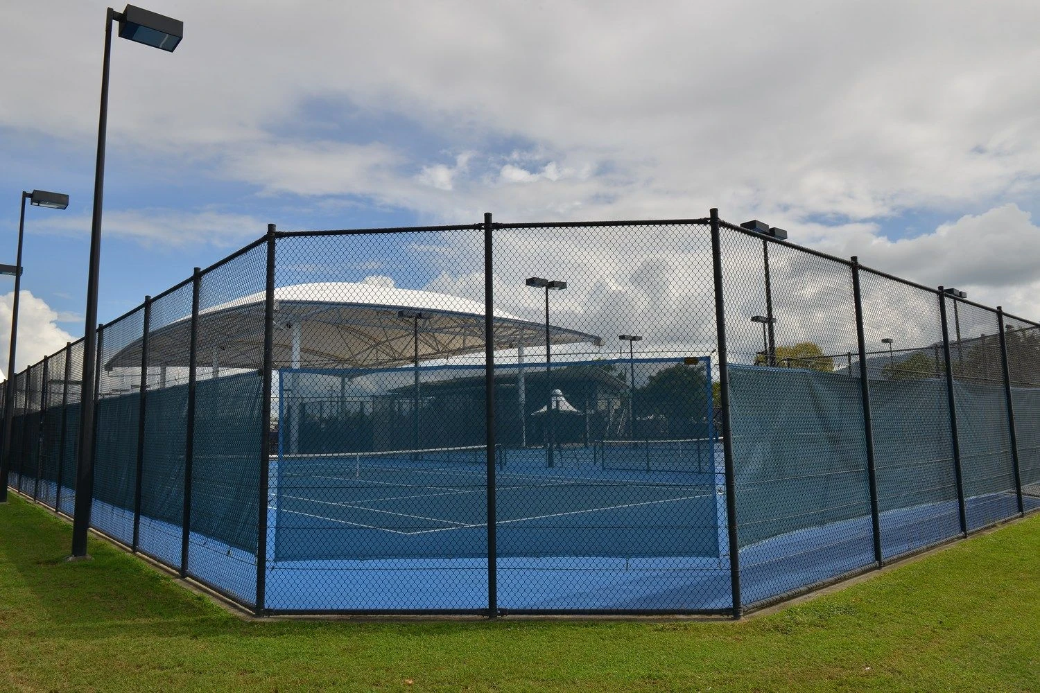 Chain wire fencing enclosing courts at a sports complex